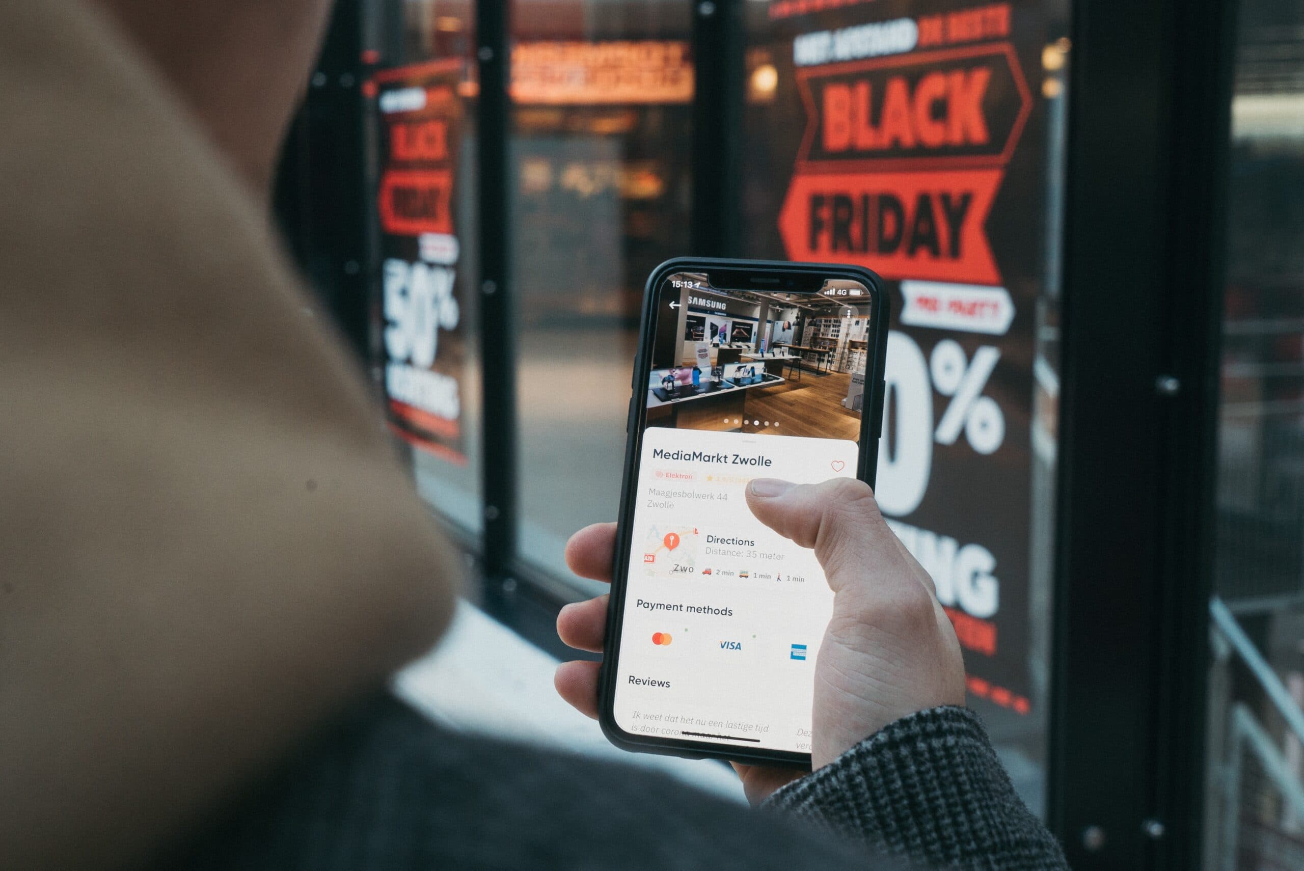 a person holding a phone checking out black friday deals
