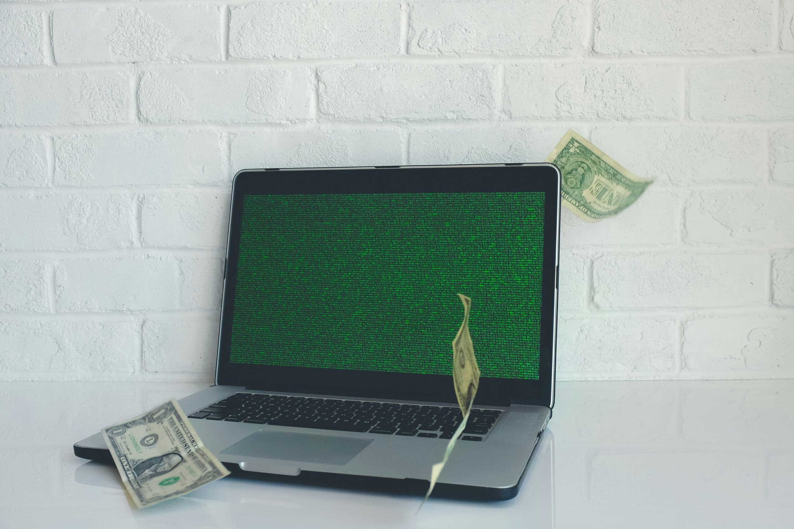 laptop with dollar bills