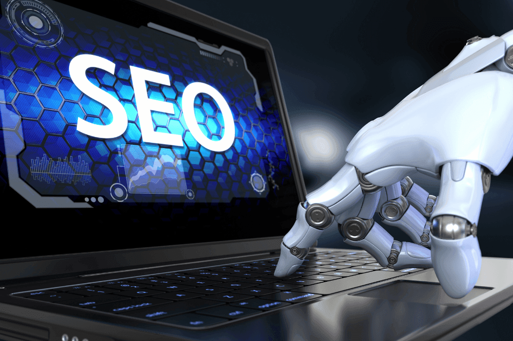 laptop with SEO on the screen and a robot hand pressing a button on the keyboard.png