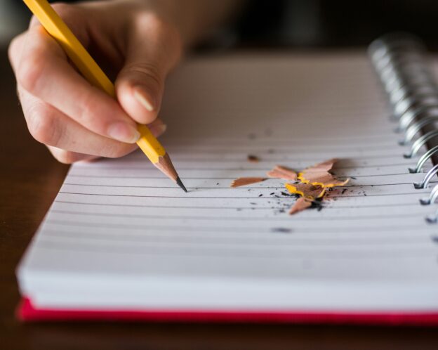 person writing on a notebook