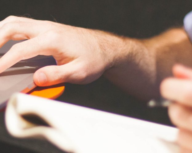 Man using a laptop and taking notes