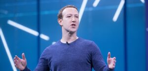 Mark Zuckerberg lifts his hands as he delivers a talk about Meta.