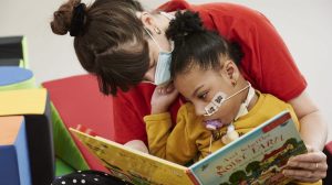 a carer reading a book to a child