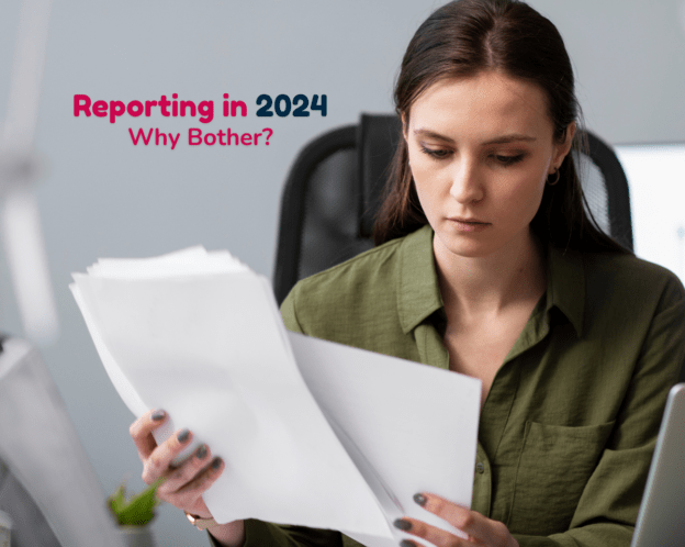 A woman in smart clothing holds A4 papers at her desk.