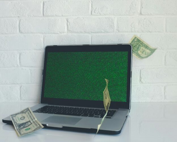 laptop with dollar bills