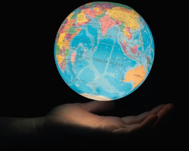 a globe floating over a hand